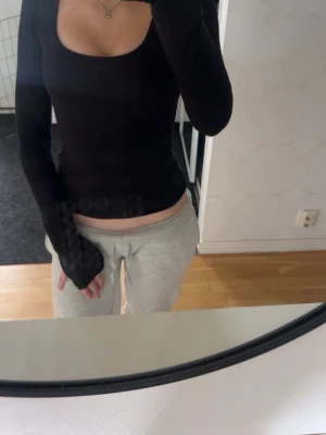 En svart långärmad tröja med urringning - Urringning och ett litet snitt på slutet av båda armarna i storlek XS/S  lite mer Basic men snygg priset går att ändra på