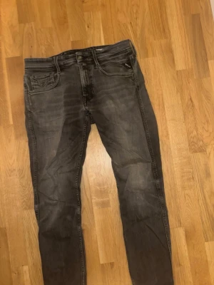 Replay Anbass Slim Fit Jeans - Säljer ett par Replay Anbass slim fit jeans i tvättad svart färg. Jeansen har smal passform och snygga slitningar för en avslappnad look. Perfekta för dig som gillar en modern och stilren stil.