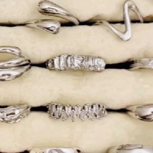 Snygga silverfärgade ringar i set (8) - Set med flera trendiga ringar i silverfärg med olika former och texturer. Några ringar har vågiga och organiska former, andra har detaljerade ytor. Perfekta för att mixa och matcha för en personlig stil.