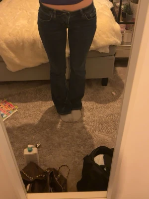 Mörkblå bootcut jeans - Säljer ett par mörkblå lågmidjade bootcut jeans. Jeansen har en utsvängd passform nedtill och är tillverkade i ett denimtyg med lätt stretch. Perfekta till sneakers eller boots. Varsamt använda, sällan. Mycket bra skick. Köpta för 850