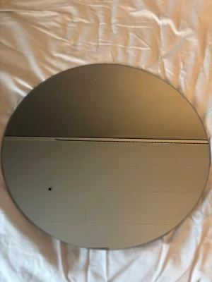 Rund spegel i minimalistisk stil - Säljer en rund spegel med enkel och stilren design. Spegeln har en slät yta och baksida med upphängningsfäste. Perfekt som inredningsdetalj i hall, sovrum eller badrum. Spegeln är helt utan ram och har en modern känsla.