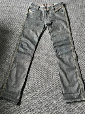 Diesel bootcut jeans - Säljer ett par riktigt snygga mörkblå diesel jeans med bootcut stil och tydliga kontrastsömmar. Klassisk femficksmodell med knapp- och dragkedjegylf. Jeansen har en något tvättad look och passar riktigt fint till en skön archive stil.  Bara att höra av sig vid frågor och priset är alltid diskuterbart vid snabb affär.