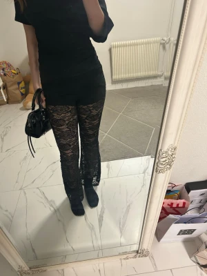 Svarta spetsbyxo - Säljer ett par svarta leggings i genombruten spets byxorna är utsvängda. De är för korta för mig och jag är 169cm Materialet är stretchigt och följsamt.