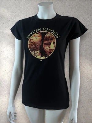 Svart t-shirt Return to Roots print - Svart t-shirt med rund hals och korta ärmar. Framsidan har ett stort tryck med texten 'Return to Roots' och ett konstnärligt motiv i beige och bruna toner. 