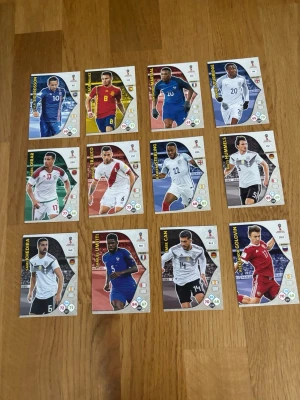 FIFA World Cup 2018 samlarkort Panini - Säljer ett set med officiella FIFA World Cup 2018 Adrenalyn XL samlarkort från Panini. Korten har färgglada motiv på olika fotbollsspelare och landslag, med detaljerade stats och landslagsdräkter. Perfekt för dig som gillar fotboll och samlarprylar. Skicka för mer information.