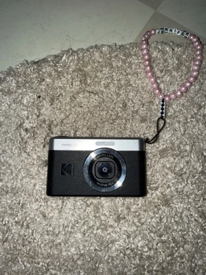 Kodak PIXPRO C1 digitalkamera  - Säljer min Kodak PixPro C1 📸✨ Perfekta lilla kameran om du vill ta cute bilder utan att alltid använda mobilen!! Den har flip-skärm så den är SÅ bra för selfies/vloggar, och ger lite den där retro/softa känslan i bilderna. Köpt för 1250kr i somras och knappt använd, Säljer för 850kr. Få repor på metalldelarna, men INGET som försämrar kameras kvalitet!! USB C sladd som laddare. 
