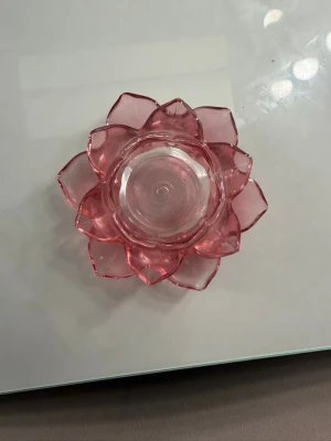 Rosa ljuslykta i glas, blomformad - Säljer en dekorativ ljuslykta i glas med blomformad design i rosa färg. Perfekt som inredningsdetalj på bord eller hylla. Ljuslyktan har flera lager av kronblad och plats för ett värmeljus i mitten.