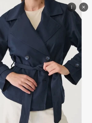 Mörkblå kort trenchcoat med bälte - Jackan är helt ny med prislappp kvar skriv för mer bilder. För liten för mig FINNS ÄVEN I STORLEK S KIKA PÅ MIN PROFIL