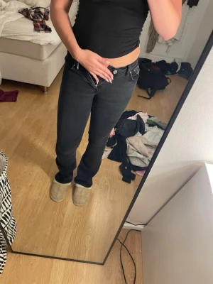 Svarta bootcut jeans från Gina - Säljer ett par svarta bootcut jeans från Gina. Jeansen har klassisk femficksdesign, normalhög midja och raka ben med lätt utsvängning nertill. Perfekta till sneakers eller boots och riktigt sköna att bära hela dagen.