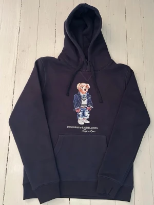 Ralph Lauren polo bear hoodie storlek S  - Hej! Säljer denna riktigt schyssta polo bear hoodie från Ralph Lauren. Den är i storlek M men sitter en storlek litet och passar därför som en S. Den är endast använd någon enstaka gång och är därmed i ett nyskick (om den ser fläckig/ solblekt ut så är det endast pga dåligt fotoljus). Original lappar och påse finns kvar och medföljer naturligtvis vid köp. Jag fraktar alltid snabbt! Mvh
