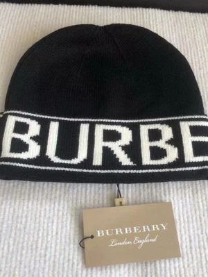 Svart mössa från Burberry - Snygg svart mössa från Burberry med vit logotyp runt kanten. Klassisk och stilren design som passar perfekt till kalla dagar. Mössan är stickad och har en mjuk känsla. Perfekt accessoar för dig som vill ha något trendigt och bekvämt.