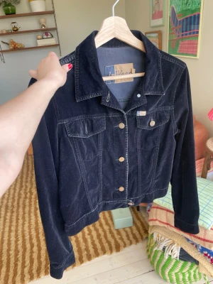 Vintage vårjacka sammet  - Vintage jacka i svart sammet. Strl 36. Tyget är lite bortskavt på ena axeln och saknas en knapp på ena bröstfickan, annars fint skick!