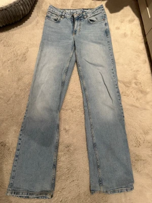 Ljusblå raka jeans från Bikbok - Säljer ett par ljusblå jeans från Bikbok med rak passform och klassisk femficksdesign. Jeansen har normal midja och är tillverkade i ett mjukt denimtyg. Perfekta för en avslappnad och trendig look. Har använt dem några gånger, men nu har de legat i garderoben ett tag.