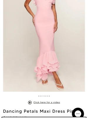 Ljusrosa långklänning med volang - Superfin ljusrosa långklänning med smala axelband och volangdetaljer längst ner. Klänningen har figurnära passform och en romantisk look med volanger som ger extra rörelse. Perfekt för dig som vill sticka ut med en feminin och elegant stil.