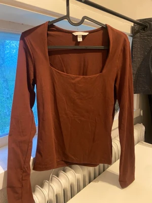 vinröd långärmad topp med fyrkantig ringning - Snygg vinröd långärmad topp från H&M med fyrkantig ringning. Tillverkad i mjuk bomull och har en slim passform som sitter snyggt på kroppen. Perfekt att styla med jeans eller kjol för en trendig look. vinröd i verkligheten 