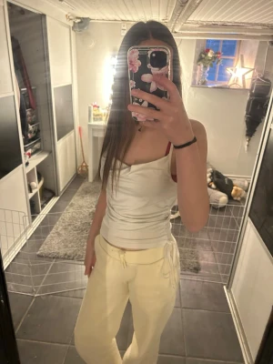Vit omlott-linnetopp från Gina Tricot - Snygg vit omlott-linnetopp från Gina Tricot med smala axelband och figurnära passform. Toppen har en lätt glansig yta och är perfekt att styla med jeans eller kjol. Enkel och stilren design som passar till många looks❤️