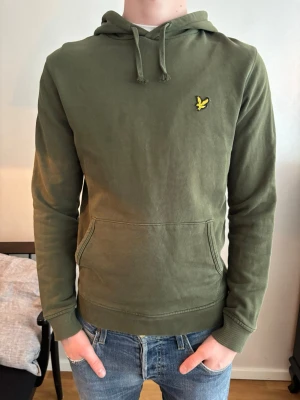 Olivgrön hoodie från Lyle & Scott - Jag säljer nu en riktigt skön olivgrön hoodie från Lyle & Scott med den gula loggan på bröstet. Jag säljer den för endast 249kr! Om du har några funderingar så är det bara att fråga.