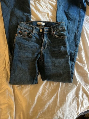 Högmidjade bottcut jeans  - Säljer högmidjade bootcutbjeans från gina. Jeansen har normal midja, knappgylf och är gjorda i ett slitstarkt denimtyg. Perfekta till en avslappnad stil och funkar året runt.
