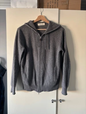 Grå hoodie i ull med dragkedja - Mysig grå hoodie från sayless i 100% cashmere . Tröjan har dragkedja framtill, två fickor och justerbar huva med snören. Storlek xs men sitter lite större mer som S