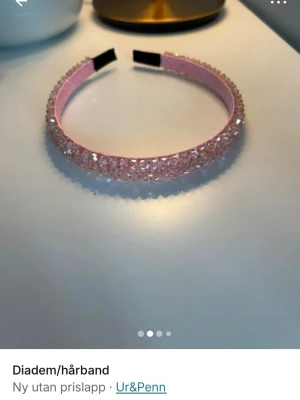 Rosa diadem med glittrande stenar - Snyggt rosa diadem från Ur&Penn dekorerat med glittrande kristalliknande stenar. Diademet har en klassisk rund form och insida i ljusrosa tyg. Perfekt accessoar för att lyfta din look med extra bling.