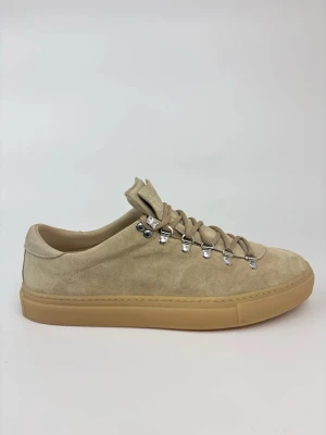 Beige sneakers i mocka från Diemme - Snygga beige sneakers från Diemme i mjuk mocka med grova snören och metallöglor. Skorna har en klassisk låg profil och en gummisula i ljusbrun ton. Perfekta för dig som gillar stilrena och trendiga detaljer.
