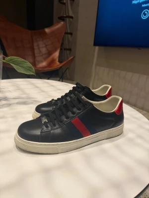 Ace Black Leather  - Svarta läder Gucci ace skor i väldigt fint skick. Använda max 5 gånger. Köpta för runt 3000kr. Kvitto och box hittas inte just nu men kan nog lösa fram vid starkt behov.