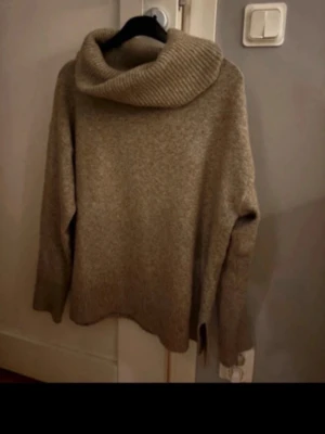 Beige stickad polotröja - Mysig beige stickad tröja med bred polokrage och långa ärmar. Använd fåtal gånger. Sticks inte 