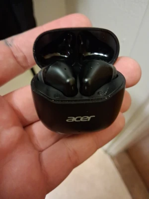 Svarta trådlösa in-ear hörlurar Acer - Säljer ett par svarta trådlösa in-ear hörlurar från Acer. Hörlurarna kommer med ett matchande laddningsetui i blank plast och har en stilren, modern design. Perfekta för musik, poddar eller samtal på språng.