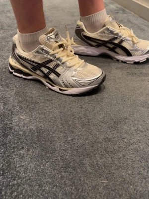 ASICS Gel-Kayano 14  - Snygga ASICS Gel-Kayano 14 sneakers i beige mesh med silvriga och svarta detaljer. Skorna är i storlek 44 men passar dig som har 43 