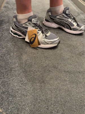 Asics gel kayano 14 - Snygga ASICS sneakers i grått och silver med svarta detaljer. Skorna är i storlek 44 fast passar dig som har 43