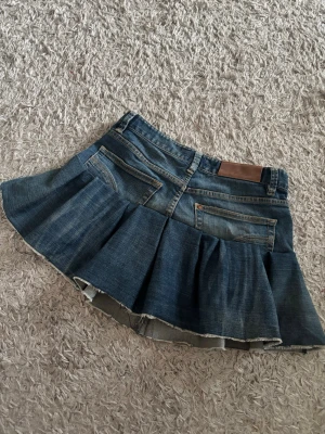 Mörkblå jeanskjol med fickor - Supersöt blå jeanskjol med volang som är omsydd från ett par jeans💞  Midjemått - 37 cm  Längd framsida - 32 cm  Längd baksida - 33 cm  #denim #jeanskjol #sommar #vår #volangkjol #stockholmsstil #copenhagenstyle #trending #trendy #vintage 
