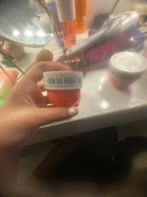 Sol de Janeiro Bom Dia Bright Cream - Bom Dia Bright Cream från Sol de Janeiro i en liten rund burk med vit lock och orange botten. Krämen är känd för att ge lyster och återfukta huden, perfekt för dig som vill ha glow och mjuk hud. Doften är fräsch och burken är smidig att ta med i väskan.