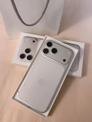 Iphone 17 pro max 512GB - Snygg vit iPhone 17 PRO max  med stilren design och trippelkamera på baksidan. Mobilen har rundade kanter, glasbaksida och metallram. Perfekt för dig som gillar modern teknik och vill ha en clean look.