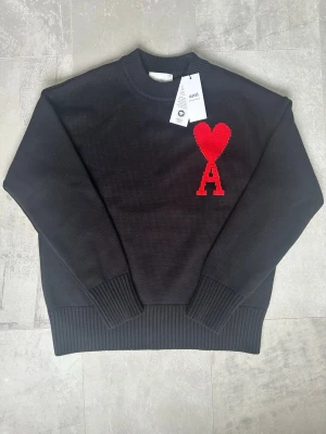  Ami Paris tröja - Snygg svart stickad tröja från Ami Paris, för dig som letar efter den perfekta tröjan till våren. Den är helt ny och oanvänd (med tags). 