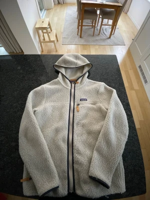 Patagonia Fleece hoodie - Beige Patagonia fleece hoodie/jacka i storlek S/M. Svår att få tag på och säljs inte längre. Skick 9.5/10, endast använd några få gånger. Perfekt nu under vintern/våren. Hör av er med frågor!