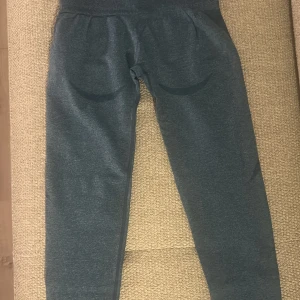 Nvgtn  leggings - Säljer ett par mörkblåa  sömlösa leggings från NVGTN med hög midja och diskreta detaljer längs benen. Materialet är stretchigt och mjukt, perfekt för träning. Inga synliga loggor eller märken. Snygg passform som framhäver benen. Endast 1 gång använda. Köptes för 2 år sedan för 580