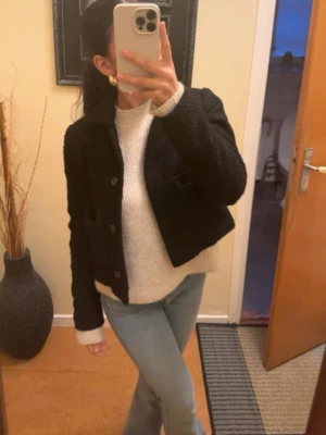 Svart kappa  - Stilren svart kappa från Aware med grovstickad struktur. Jackan har knappar framtill, två fickor och klassisk krage. Använd fåtal gånger, köpt ifrån Veromoda för 500kr