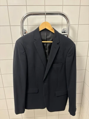 Svart kavaj från Lindbergh White - Stilren svart kavaj från Lindbergh White & matchande kostymbyxor i slim fit. Använd vid 2 tillfälle, i toppen skick.