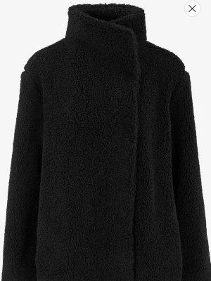 Svart teddyjacka med hög krage - Helt ny med prislapp. Mysig svart teddyjacka från Cellebs of Sweden med hög krage och rak passform. Jackan har en fluffig, mjuk yta i teddy-material ock stängs framtill. Perfekt för kalla dagar när du vill vara både varm och stilren. Kontakta vid frågor eller för fler bilder❤️