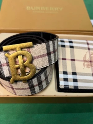 Burberry bälte - Snyggt Burberry 125cm långt bälte i beige, svart och rött klassiskt rutmönster. Bältet har ett stort guldfärgat TB-spänne och är gjort i läder med präglad logga på insidan. Perfekt accessoar för att lyfta din outfit.