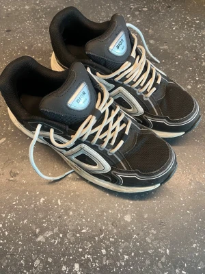 Zara - Snygga sneakers i svart med vita och grå detaljer. Skorna har en sportig design med mesh och läderpaneler samt vita snören. Perfekta för dig som vill ha en exklusiv och trendig look med streetkänsla.