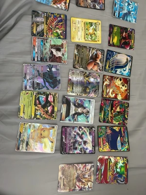 Samling Pokémonkort GX/EX/V - Stor samling Pokémonkort med flera GX, EX och V-kort i färgglada och glansiga designer. Motiven visar olika Pokémon i actionfyllda poser och korten har detaljerade illustrationer med metallic-effekter. Perfekt för samlare eller Pokémonfans som vill utöka sin kortlek.