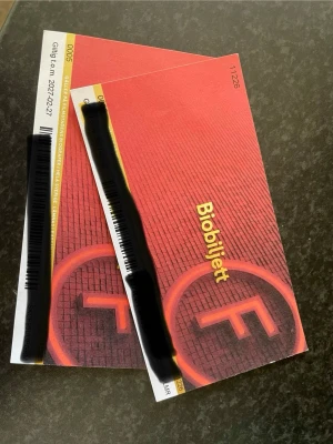 Två röda biobiljetter SF - Två biobiljetter från SF i rött och gult med texten 'Biobiljett' på framsidan. Biljetterna är i pappersformat och har tydliga SF-loggor. Perfekt för en biokväll med någon du gillar. Giltiga t.om 2027-02-27. Pris kan diskuteras