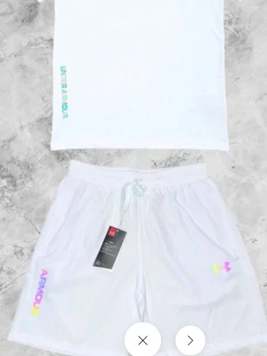 Vita shorts från Under Armour - Fräscha vita shorts från Under Armour med färgglad logga på vänster ben och snörning i midjan. Perfekta för en sportig look och tillverkade i ett lätt och bekvämt material. Pris kan diskuteras vid snabb affär