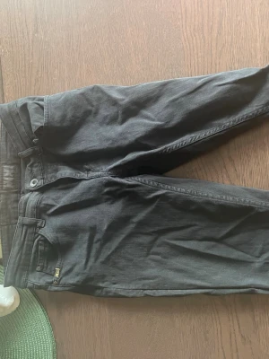 Svarta jeans med rak passform (tiger of Sweden) - Säljer ett par svarta jeans med klassisk rak passform och fem fickor. Jeansen har bälteshällor, knapp- och dragkedjegylf samt diskreta sömmar. Perfekta till en avslappnad stil och funkar året runt.