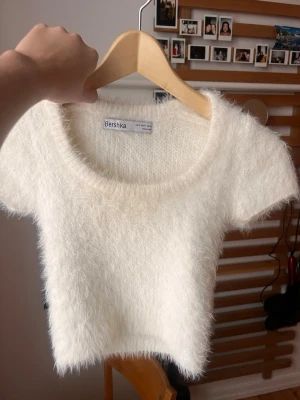 Vit fluffig topp från Bershka - Supermjuk och fluffig vit topp från Bershka med korta ärmar och rund halsringning. Croppad modell som ger en trendig look och passar perfekt till jeans eller kjol. Materialet är syntetiskt och känns riktigt gosigt.