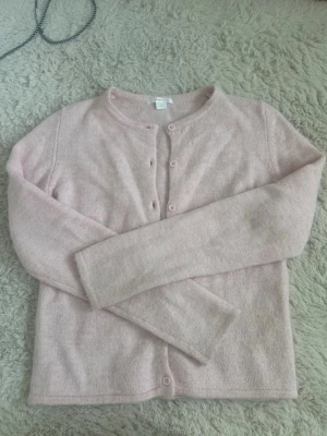 Ljusrosa kofta från Gina Tricot - Säljer en super söt ljusrosa kofta med knappar hela vägen ner i storlek 170! (S) Den är knappar använd och är då i super bra skick, den är lite mer rosa i verkligheten 💗syns tyvärr inte på bilderna!