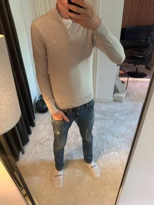 Beige halvzip  J.Lindeberg - Riktig snygg beige ziptröja ifrån j Lindeberg. Säljer då den knappt är använd. Det är storlek M med en riktigt schysst passform. Köptes för 1600kr i butik.