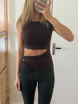 Brun topp  - Brun topp med cut out. Helt ny med lapp kvar! Man kan justera cut outen så att den blir mindre/större