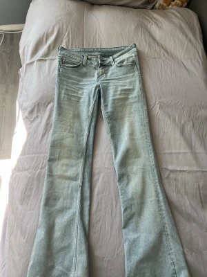 Ljusblå bootcut jeans från Cheap Monday - Säljer ett par ljusblå bootcut jeans från Cheap Monday . Jeansen har låg midja och lätt slitna detaljer framtill. Knappa använda. Är lite osäker på om de är str 27 eller 28. Längden är 34!